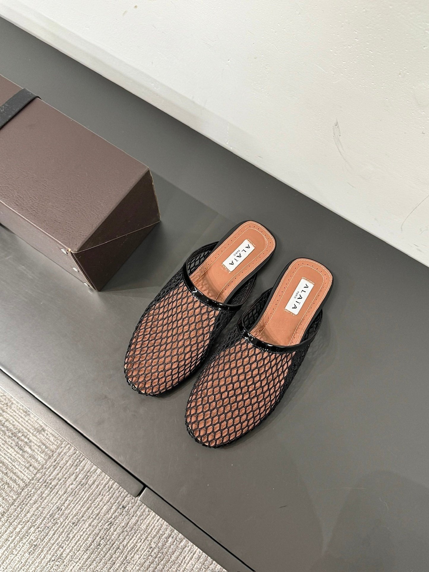 ALAIA FLAT MULES IN BLACK MESH FISHNET