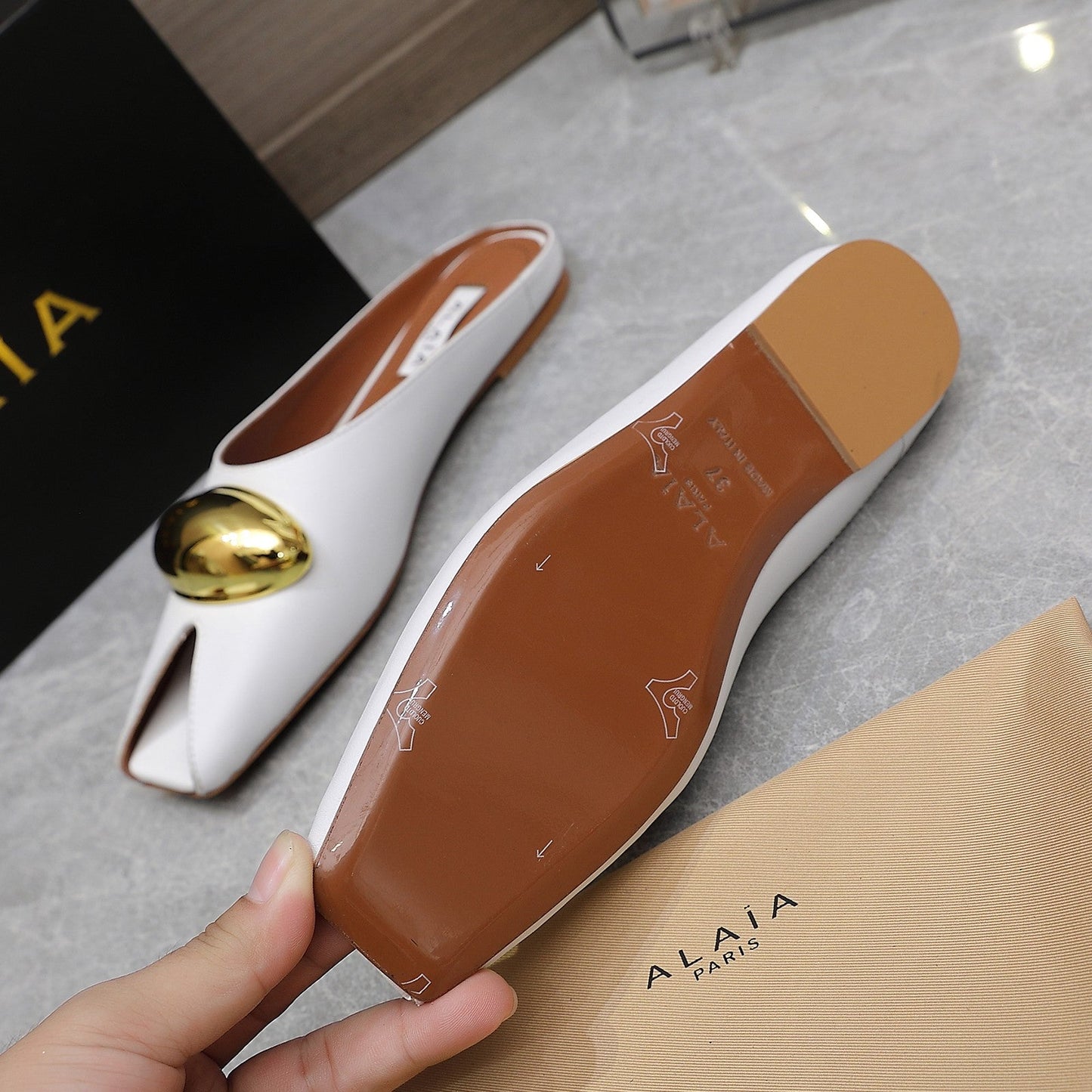 ALAIA FLAT MULE IN WHITE LAMBSKIN WITH GOLD HARDWARE